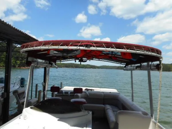 Slide: The Image of 2002 Harris-Kayot Royal Heritage 260 boat with red canopy on a lake. - 20