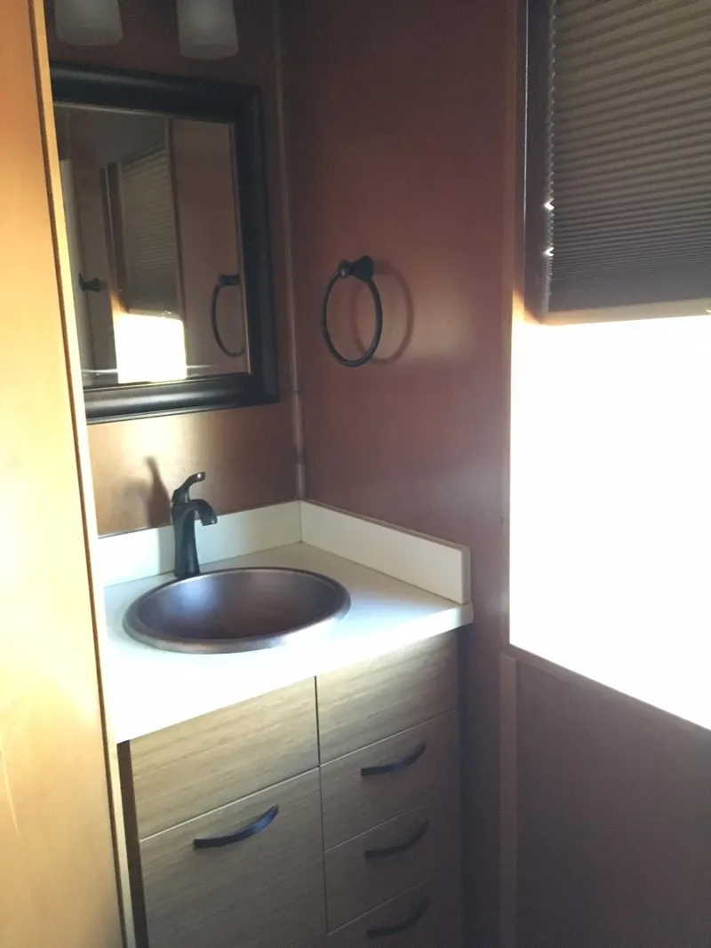 Slide: The Image of Compact bathroom in 2014 Bravada Imagination Trip #15 RV with sink and mirror. - 19