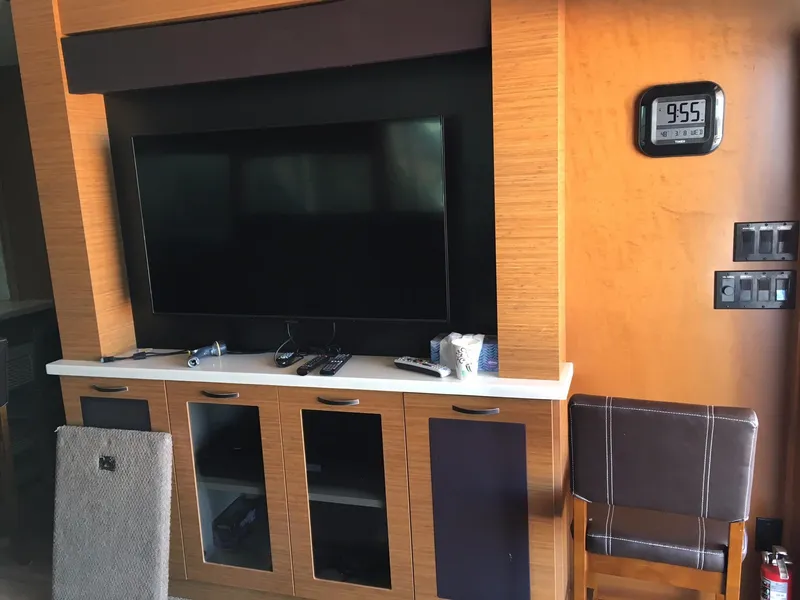 Slide: The Image of Entertainment center with TV, digital clock, and wooden cabinets in a Bravada Imagination Trip #15, 2014. - 7