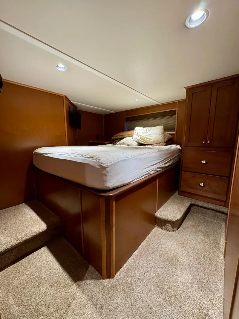 Slide: The Image of Cozy bedroom in 2012 Bravada Helios Trip #8 houseboat with wood cabinetry and carpeted flooring. - 12