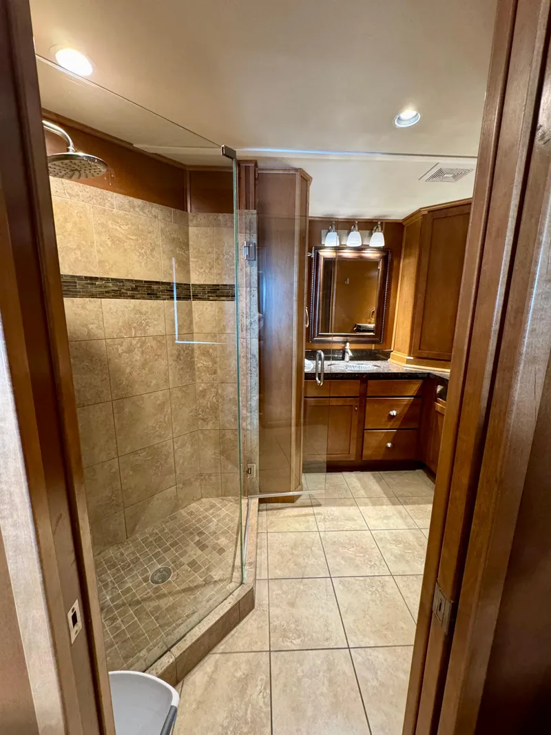 Slide: The Image of Luxurious bathroom in 2012 Bravada Helios Trip #8 with glass shower and wooden cabinetry. - 7