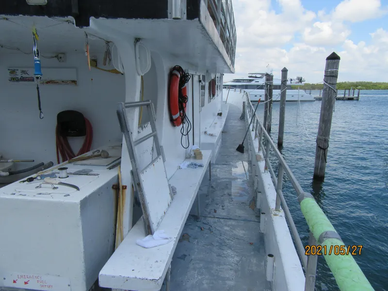 Slide: The Image of Commercial drift fishing boat docked, featuring safety equipment and open deck, 1986 model. - 11