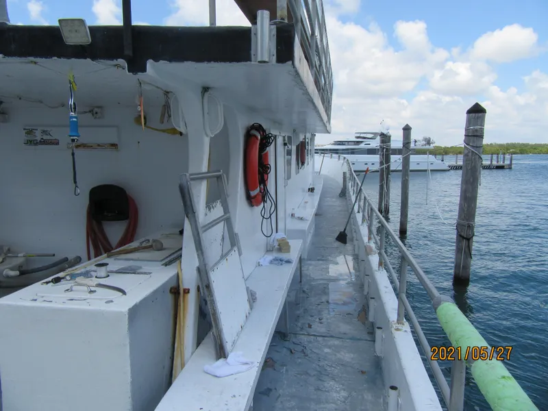 Slide: The Image of 1986 Commercial Drift Fishing Party boat docked, featuring safety equipment and open deck. - 12