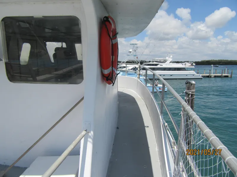 Slide: The Image of Commercial drift fishing boat deck with life preserver, docked at marina, sunny day. - 17