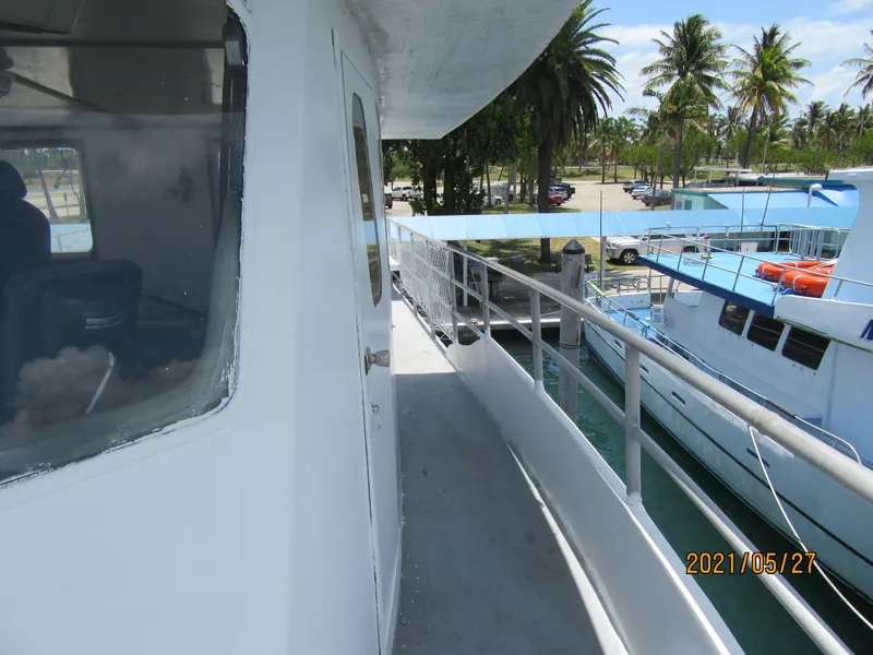 Slide: The Image of Side view of 1986 Drift Fishing Party boat docked, with palm trees in the background. - 21