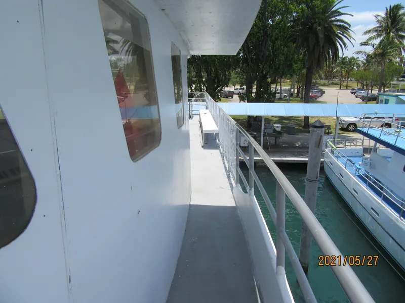 Slide: The Image of Side deck of 1986 Commercial Drift Fishing Party boat docked near palm trees. - 22