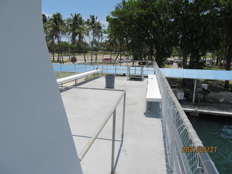 Slide: The Image of Upper deck of 1986 Drift Fishing Party boat, surrounded by palm trees and water. - 23