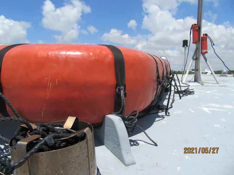 Slide: The Image of Orange life raft on a fishing boat deck under a cloudy sky. - 31
