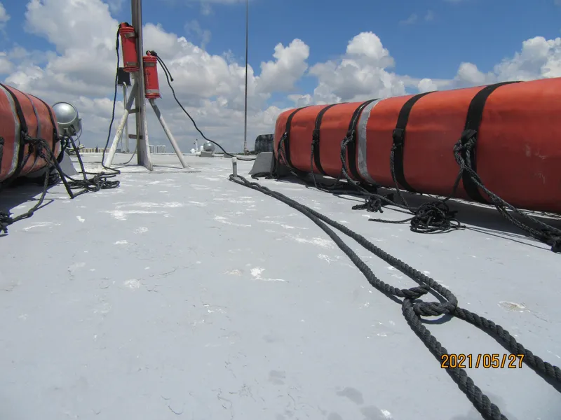 Slide: The Image of Commercial drift fishing boat deck with life rafts and ropes, under a cloudy sky. - 32