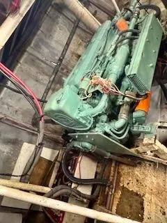 Slide: The Image of Engine room of 1986 Commercial Drift Fishing Party boat, featuring a green engine and wiring. - 48