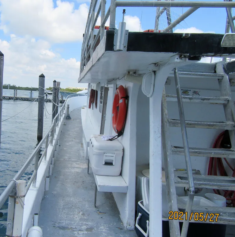 Slide: The Image of 1986 Commercial Drift Fishing Party boat docked, featuring safety equipment and upper deck access. - 8