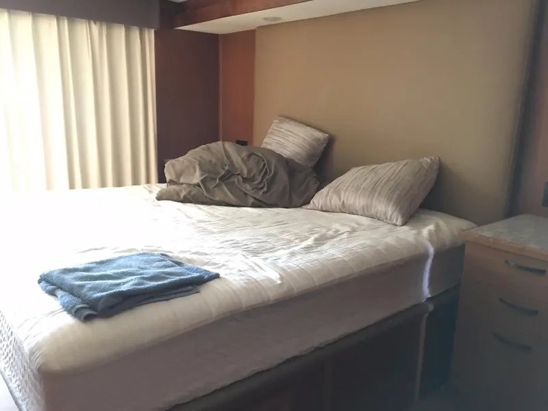 Slide: The Image of Cozy bedroom in 2014 Bravada Imagination Share RV with unmade bed and pillows. - 21