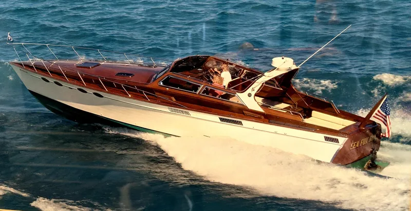 Slide: The Image of 1990 Mays Craft 44 yacht cruising on open water, displaying sleek design and American flag. - 10