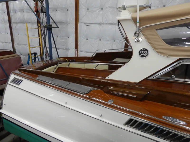 Slide: The Image of 1990 Mays Craft 44 boat with polished wood and white exterior in storage. - 14