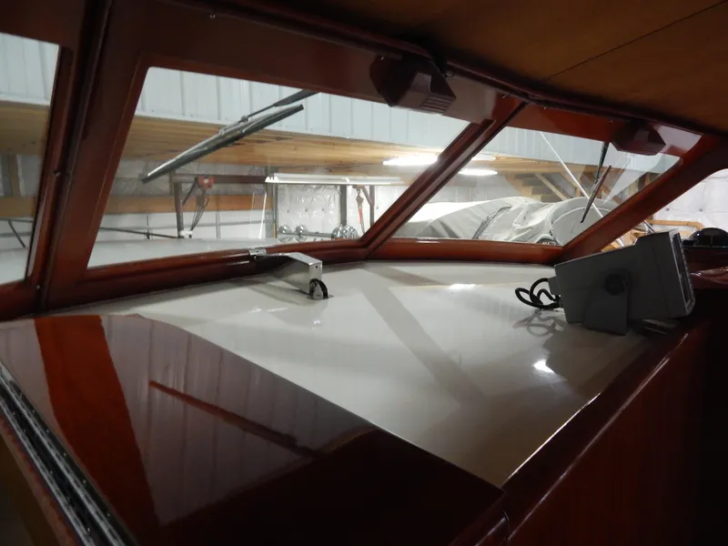 Slide: The Image of Interior view of a 1990 Mays Craft 44 boat with polished wood and large windows. - 18