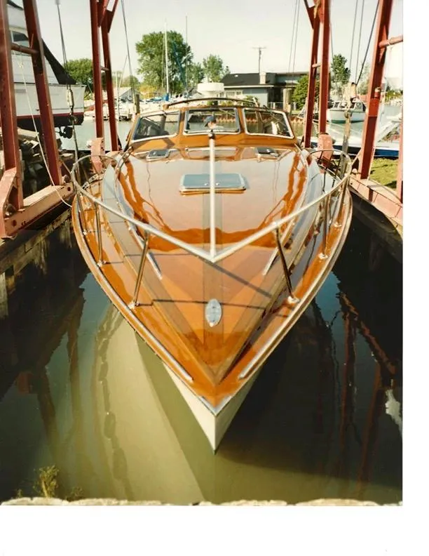 Slide: The Image of Mays Craft 44 boat from 1990, featuring sleek wooden design in a marina setting. - 2