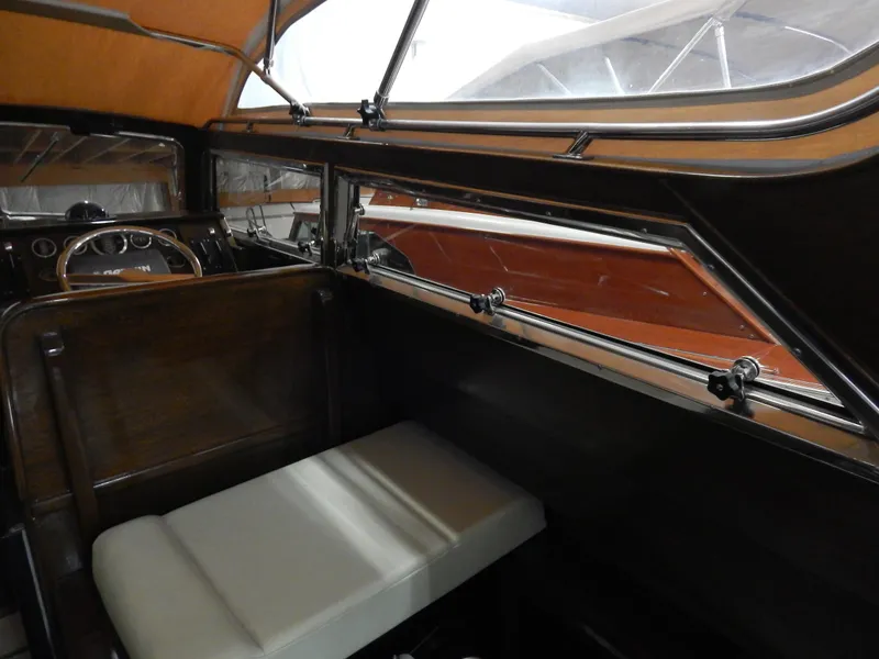 Slide: The Image of Interior of a 1990 Mays Craft 44 boat, featuring wood paneling and cushioned seating. - 24