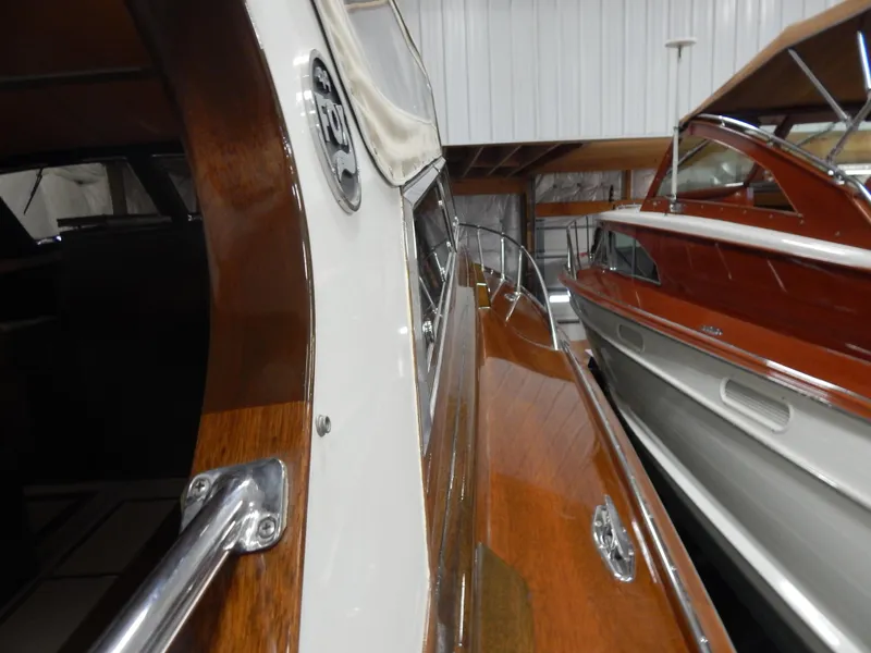 Slide: The Image of 1990 Mays Craft 44 boat with polished wood finish in a storage facility. - 26