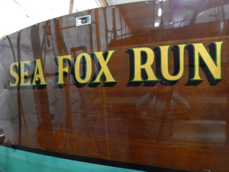 Slide: The Image of "Sea Fox Run" name on 1990 Mays Craft 44 boat with polished wood finish. - 29