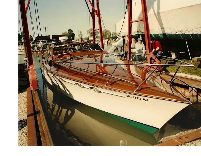 Slide: The Image of Classic 1990 Mays Craft 44 boat with polished wood finish in a marina setting. - 7