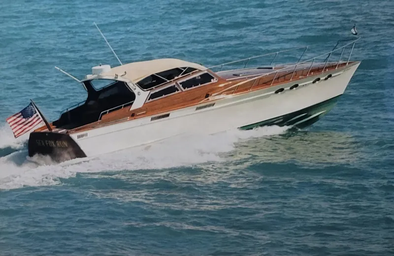 Slide: The Image of 1990 Mays Craft 44 yacht cruising on open water with American flag. - 9