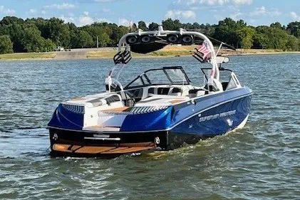 Slide: The Image of A blue and white 2015 Nautique Super Air Nautique G25 on a lake with wooded shoreline. - 3