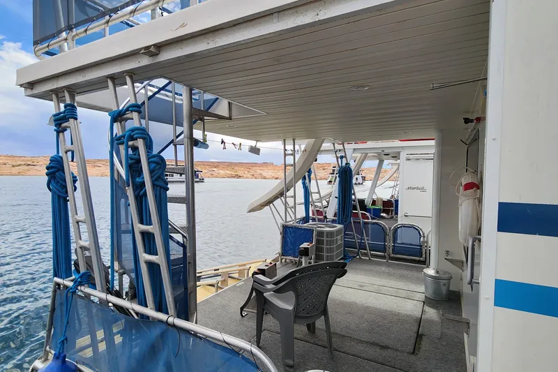 Slide: The Image of 2008 Sumerset Blue Moon Share #12 houseboat deck with chairs and ropes on a calm lake. - 24