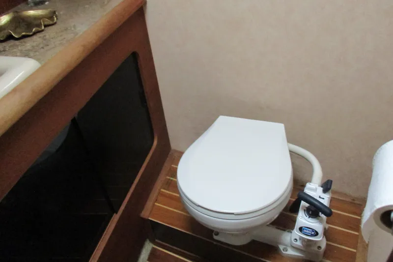 Slide: The Image of 1988 Bayliner 3888 Motoryacht bathroom with marine toilet and wooden flooring. - 15