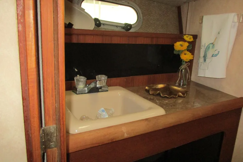 Slide: The Image of 1988 Bayliner 3888 Motoryacht bathroom sink with flowers and decorative towel. - 16