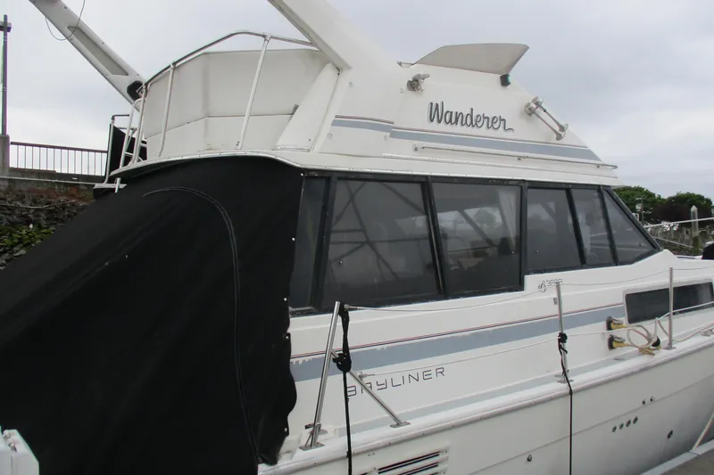 Slide: The Image of 1988 Bayliner 3888 Motoryacht docked, featuring "Wanderer" name and covered deck area. - 5