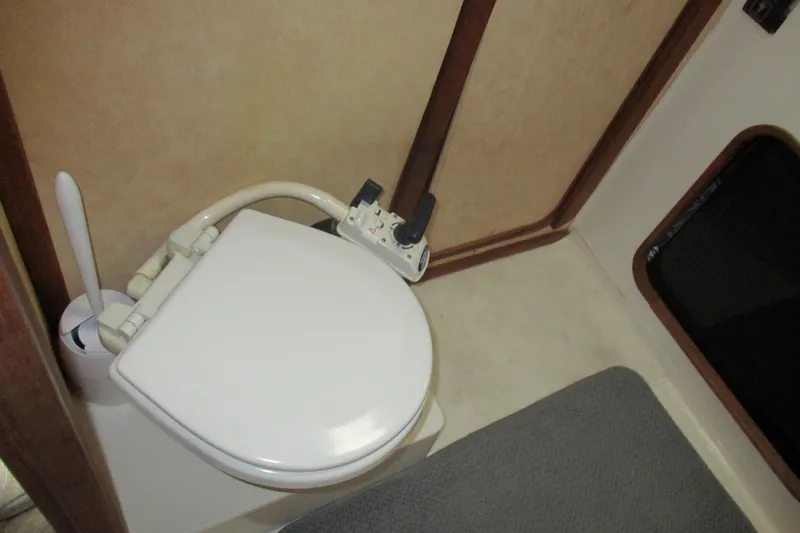Slide: The Image of 1988 Bayliner 3888 Motoryacht bathroom with marine toilet and beige interior. - 12