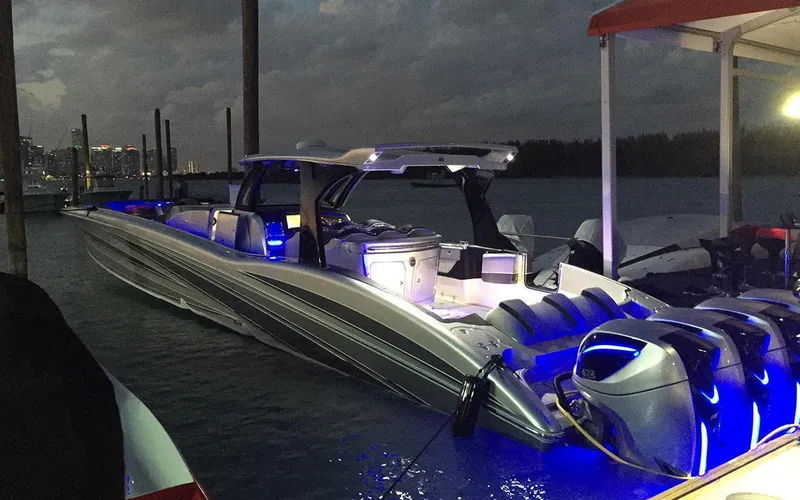 Slide: The Image of 2025 MTI V Marine Technology Inc V 57 boat illuminated at night docked by the water. - 5