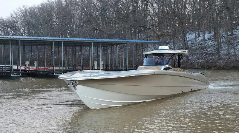 Slide: The Image of 2025 MTI V Marine Technology Inc V 57 boat cruising near a dock in a wooded area. - 8