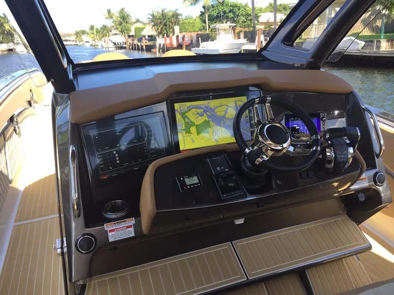 Slide: The Image of 2025 MTI V Marine Technology Inc V 42 boat dashboard with navigation screens and steering wheel. - 33