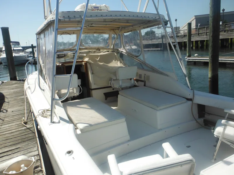 Slide: The Image of 1985 Blackfin 29 Combi boat docked at marina, featuring spacious seating and fishing area. - 11
