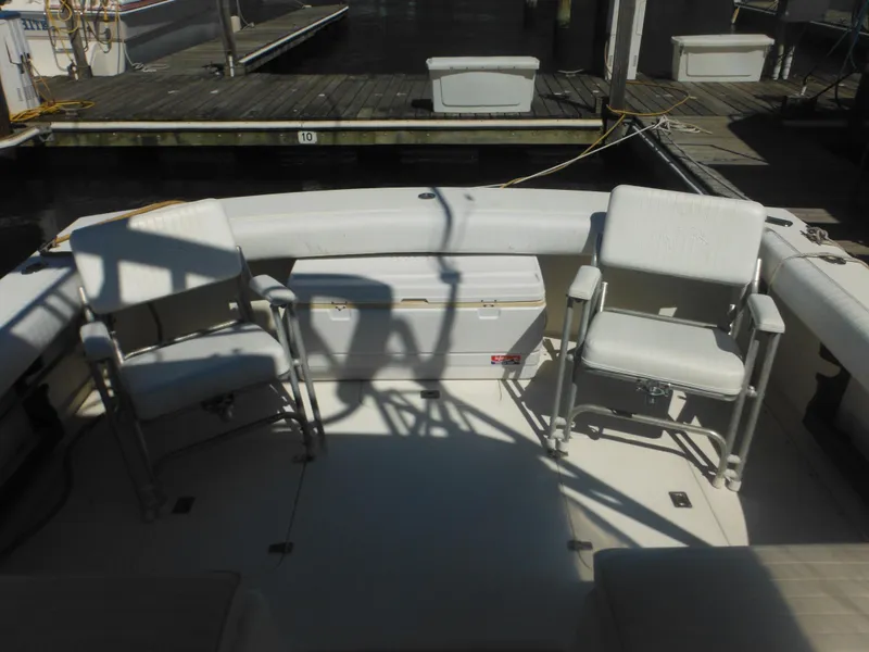 Slide: The Image of 1985 Blackfin 29 Combi boat interior with seating and dock view. - 3