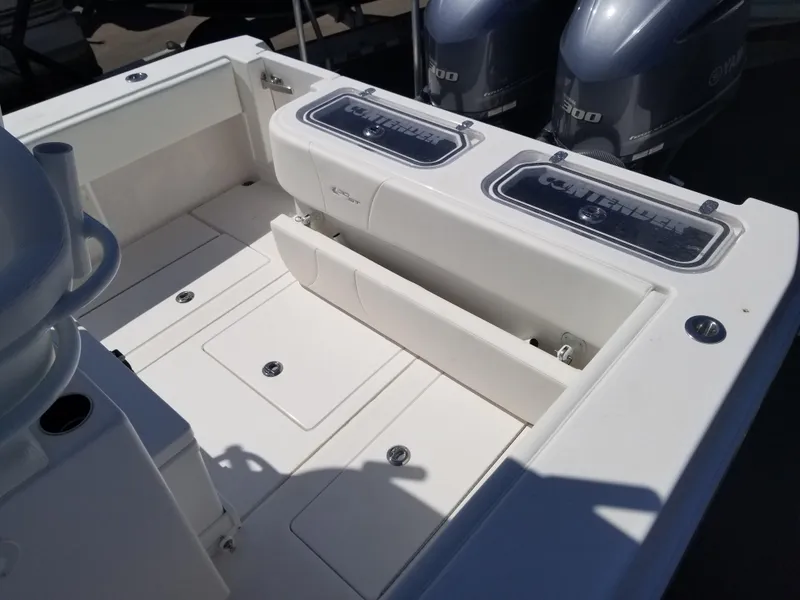 Slide: The Image of 2024 Contender 30 ST boat deck with storage compartments and twin outboard engines. - 6