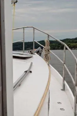 Slide: The Image of Diesel Duck 40 boat deck view, 2013 model, with railing and rope, on calm water. - 20