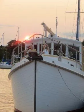Slide: The Image of 2013 Diesel Duck 40 boat at sunset, docked with sailboats in the background. - 23