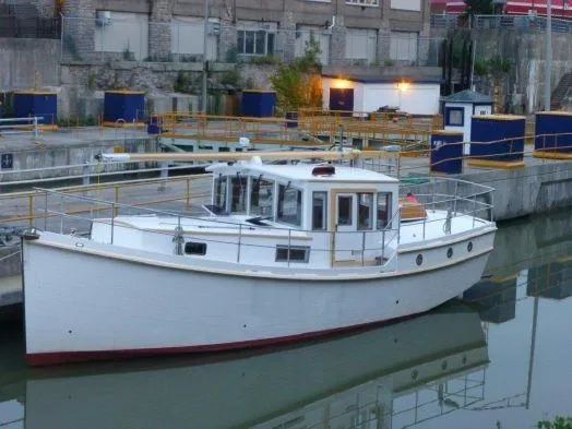 Slide: The Image of 2013 Diesel Duck 40 boat docked in an industrial marina setting. - 25