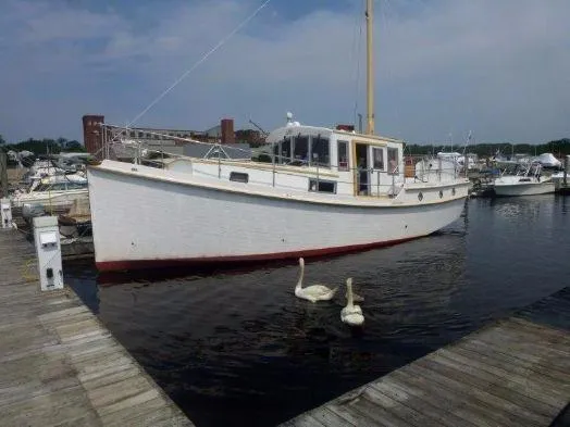 Slide: The Image of 2013 Diesel Duck 40 boat docked at marina with swans nearby. - 33