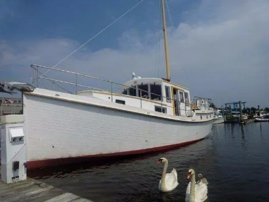 Slide: The Image of Diesel Duck 40 boat from 2013 docked, with swans in the foreground. - 34