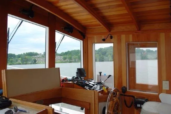 Slide: The Image of Interior view of 2013 Diesel Duck 40 boat with wooden paneling and scenic windows. - 36