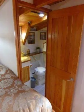 Slide: The Image of Interior of 2013 Diesel Duck 40 boat showing cozy bathroom and wooden door. - 44