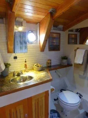 Slide: The Image of 2013 Diesel Duck 40 bathroom with wooden accents, porthole, and modern fixtures. - 45