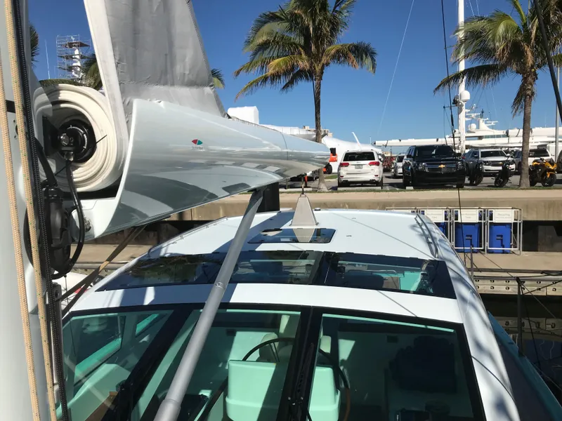 Slide: The Image of Modern Surfari 50 yacht docked, showcasing sleek design and palm trees in the background. - 12