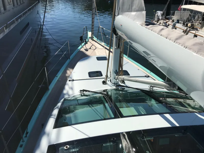 Slide: The Image of Modern Surfari 50 yacht deck, 2025 model, docked in a marina under sunlight. - 13