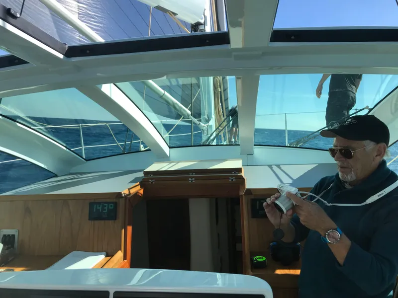 Slide: The Image of Man navigating on a 2025 Surfari 50 yacht, under clear blue skies. - 16