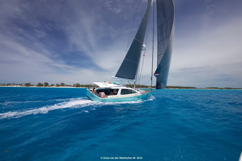 Slide: The Image of Sailing yacht Surfari 50 gliding on clear blue waters under a vibrant sky, 2025 model. - 2