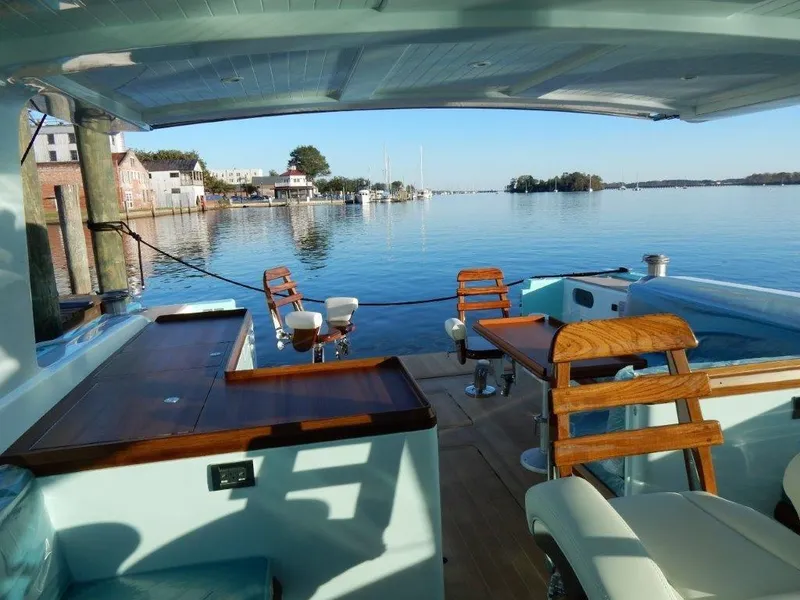 Slide: The Image of Luxurious 2025 Surfari 50 yacht interior with wooden seating, overlooking serene waterfront. - 24